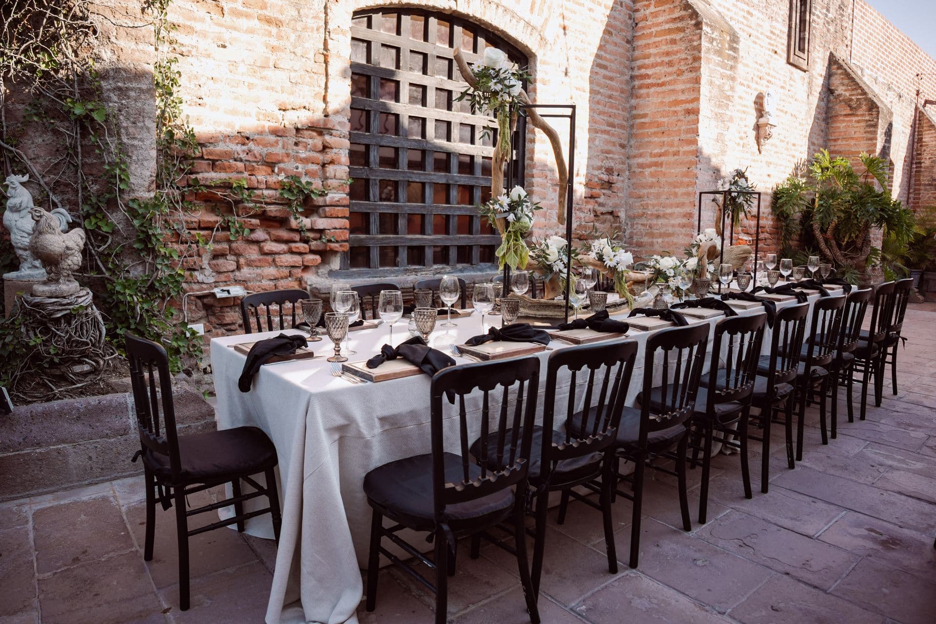 A long reception table set in a venue courtyard.