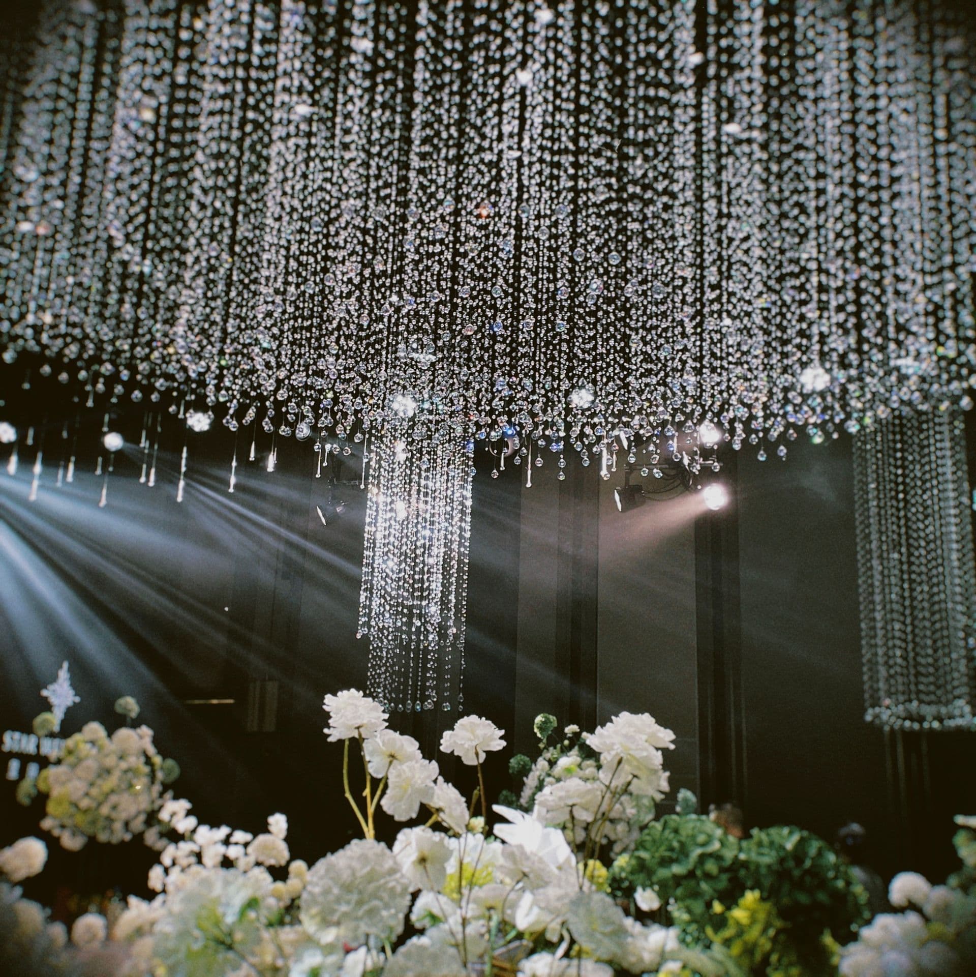 A crystal installation above reception florals at an event venue.