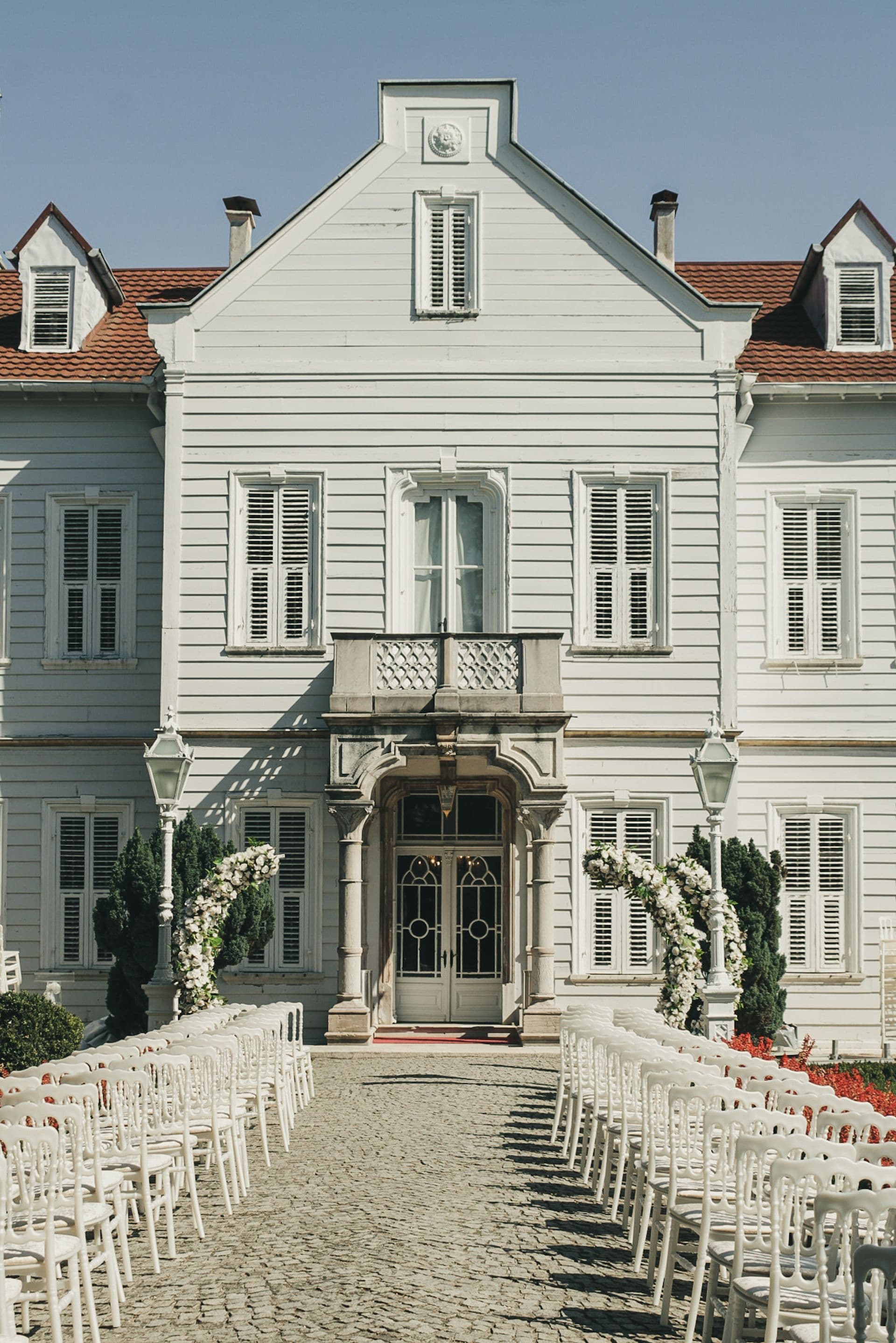 An estate venue with ceremony seating arranged outside.
