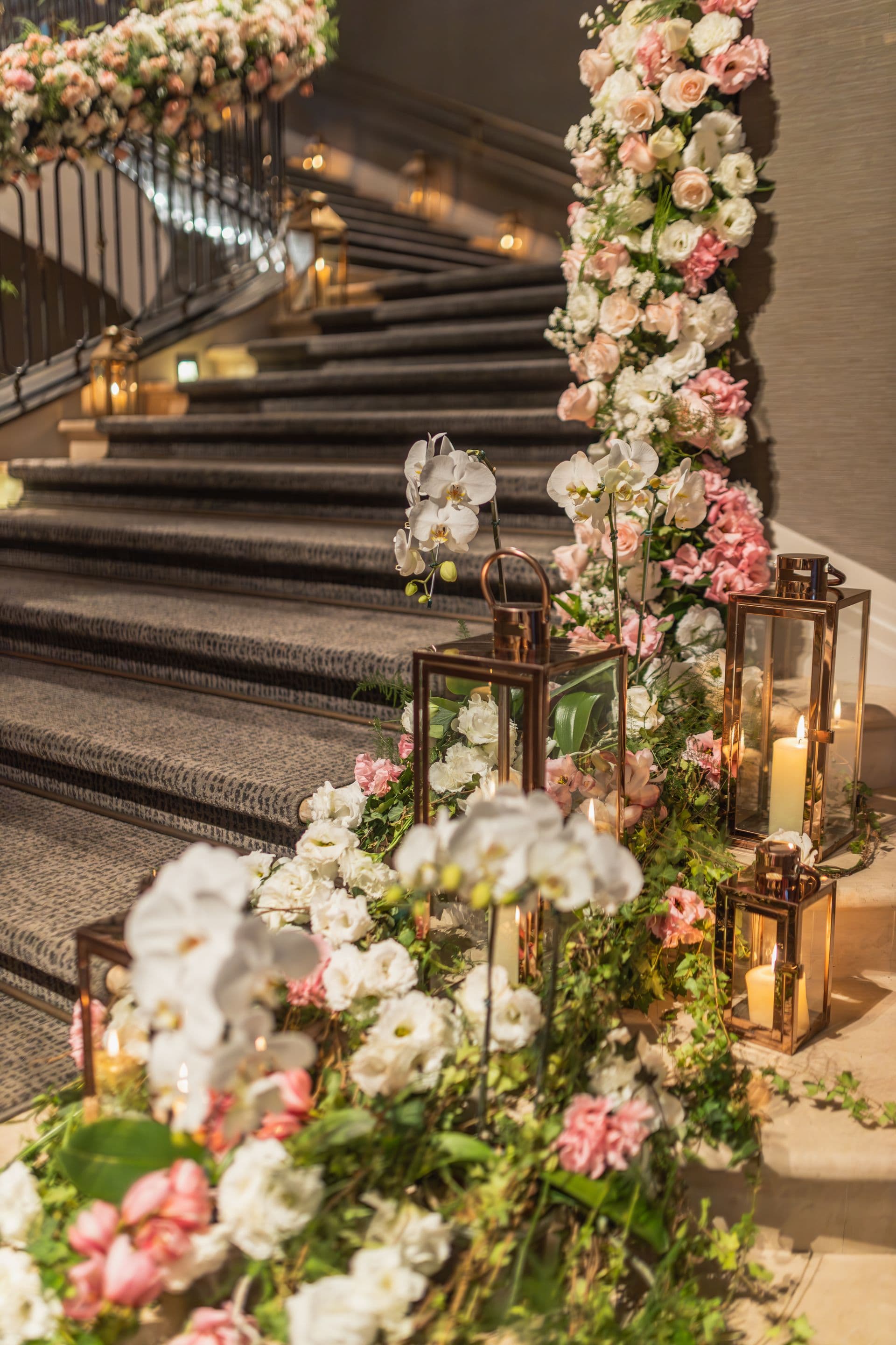 A floral-lined staircase at an event venue.
